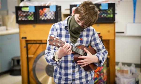 boy plays ukulele